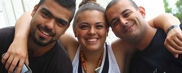 Close up of three students arm in arm.