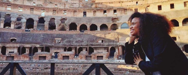 A woman smile while gazing inside the Roman Colosseum.