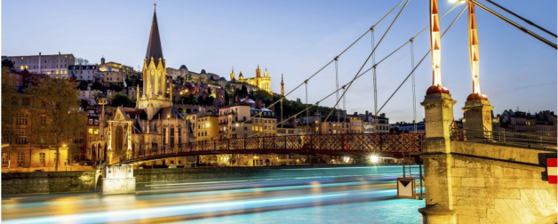 River bridge and cityscape in Lyon, France lit up in the evening