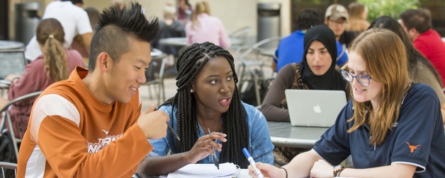 International student discuss topics at a table outside
