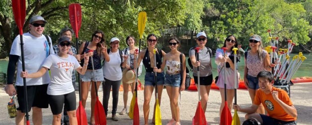 ELC group smiling with paddles with ladybird lake in the background