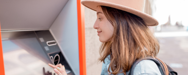 woman in hat using ATM