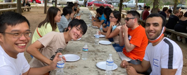 diverse student group sitting a table smiling for the group photo