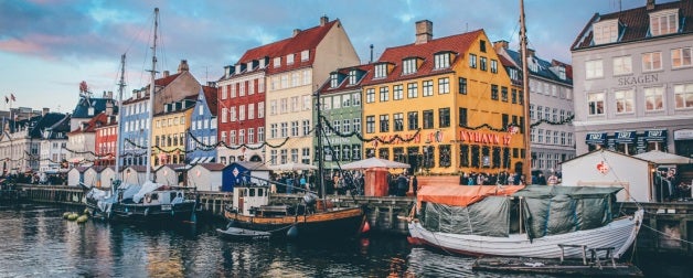 View of Copenhagen Denmark waterfront boats and colorful buildings.