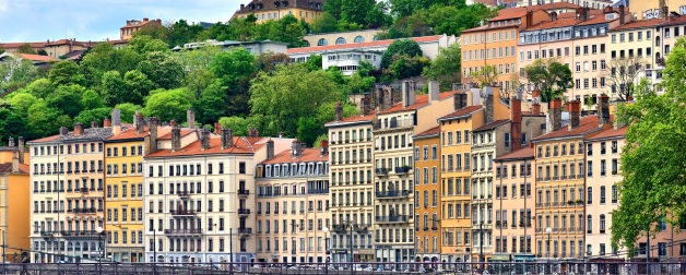 Colorful buildings with red roofs along boardwalk in Lyon, France
