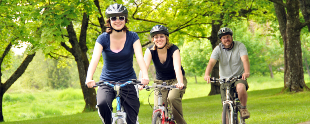 Three people riding bicycles in the park