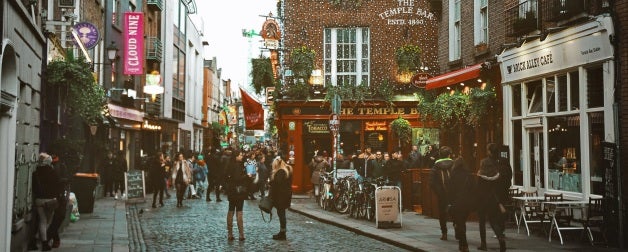 People on busy street with businesses and banners during day time