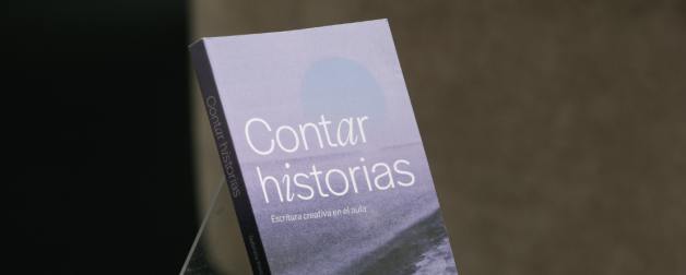 A small, purple paperback book titled, "Contar Historias" is in center of the frame