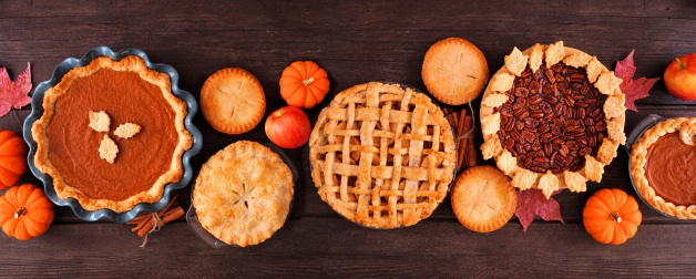 Traditional Thanksgiving pies displayed on a table with fall decor