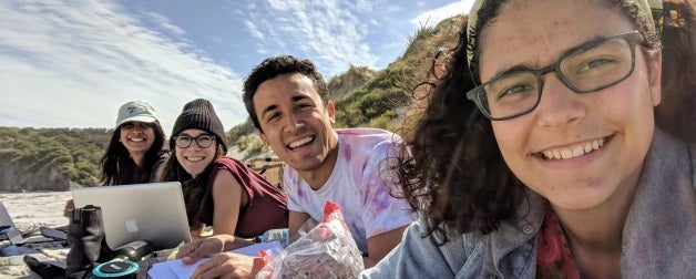 Students working together and smiling for a photo in New Zealand