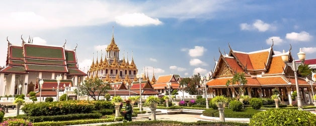Temples in Bangkok, Thailand against a beautiful blue sky and puffy white clouds day