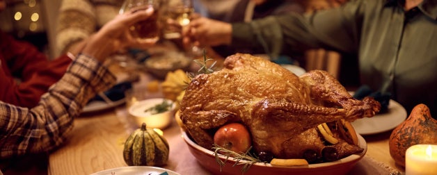 Friends gather around a thanksgiving feast to enjoy good food and good company