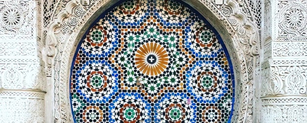 Moroccon tile is elegantly arranged on the side of a building with intricate architectural detail and flourishes