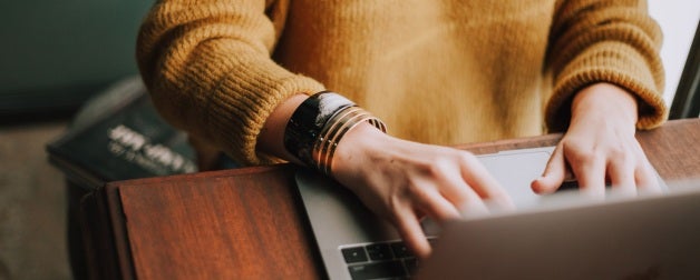a person at a desk typing on a laptop