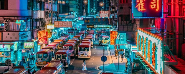 The busy Monk Kok shopping district in downtown Hong Kong is illuminated by neon signs at night