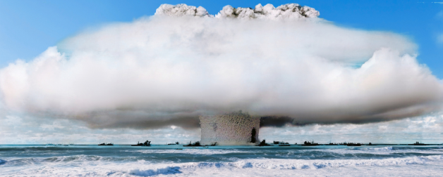A nuclear explosion test in the middle of a large body of water takes up a large amount of space in the sky.