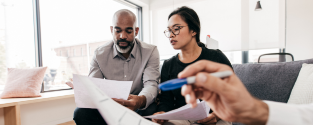 two people in an office setting look at a paper together