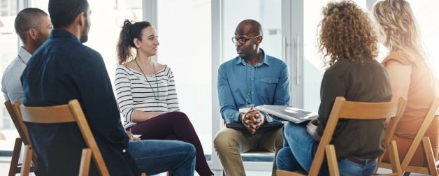 A small group of people sitting in a circle and participating in group therapy