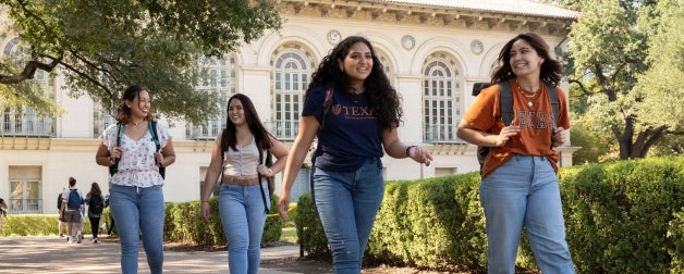 Students walk under live oaks during the day on the beautiful UT Austin campus
