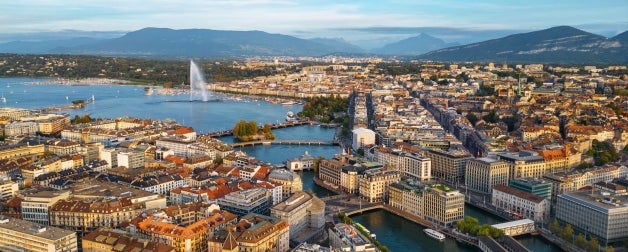 Skyline view towards the Jet d'Eau fountain in Lake Geneva with mountains in the background in Geneva, Switzerland