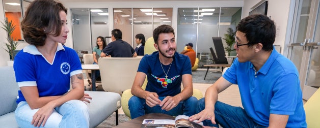 Students sit together in the Texas Global lobby engaged in discussion