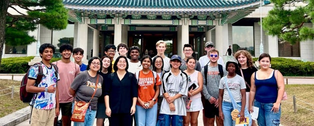 Study abroad smile for a group photo with Asian architecture in the background