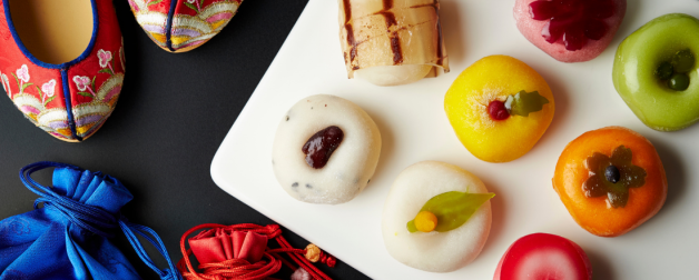 Chuseok celebration items including mochi, satin slippers, and colorful cloth