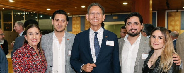 UT Texas Global alumni smile in a group photo together at an alumni event
