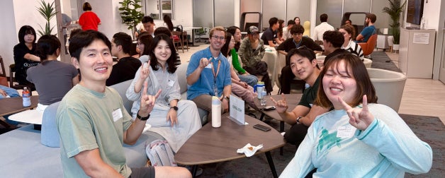 Smiling students participating in language circles of Korean, English, and Spanish