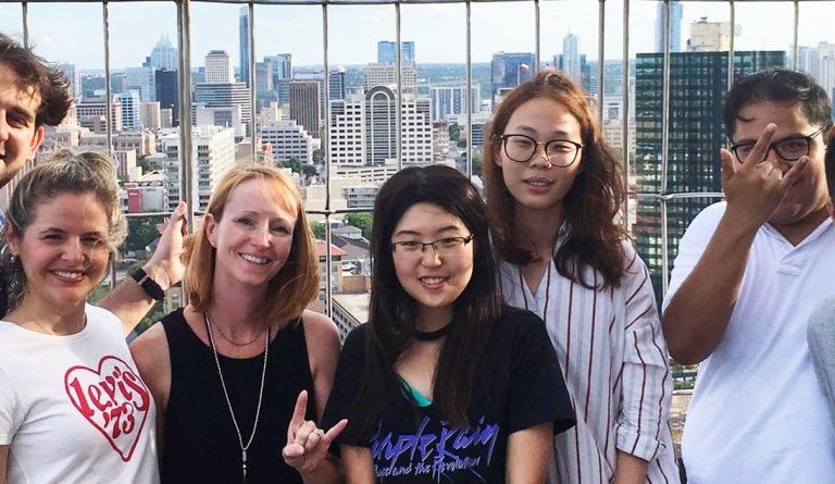 ELC teacher Dara Chambers smiles with students overlooking Austin