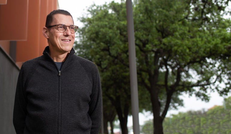 Dell Medical School Director Paul Rathouz smiles outside a UT campus building
