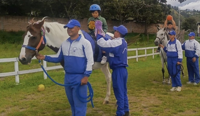 Police officers volunteer with children and horses in Ecuador