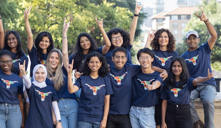 UT international students throw the Hook 'em Horns sign