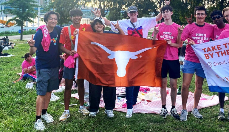 Students with Take the World by the Horns unfurl a Longhorn flag in Seoul