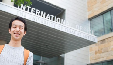UT student poses in front of Texas Global office with a smile 