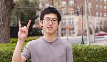UT student Chen Pang Chan poses with hook'em horns hand sign 