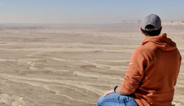 UT student is photographed staring at large dessert field 