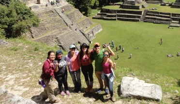 students pose next to ancient temples in central america