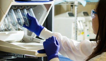 a scientist wearing gloves in a lab and using test tubes 
