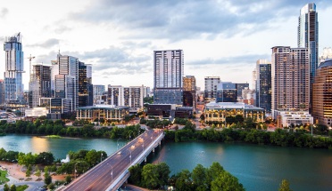 a view of the austin skyline and river at sunset