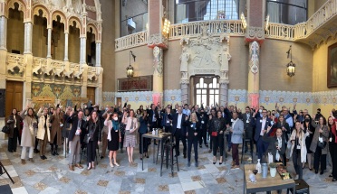 Participants at the Value Institute's Redefining Health Care Summit in Barcelona gather for a photo while doing the Hook 'em Horns hand sign. 