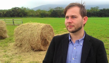 English Language Center instructor Eric Uphoff in front of a bale of hay