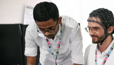 Researchers Alawieh Hussein and Kumar Satyam test brain-hand interface equipment at FILUNI 2023