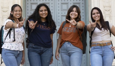 Four Latina students throw the "Hook 'em Horns" sign for UT