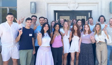 Exchange students throw "Hook 'em Horns" outside the UT Austin law library