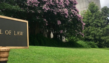 Sign and flowers in front of the University of Texas School of Law