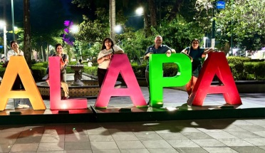 Students pose in front of city sign in Xalapa, Mexico