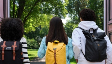 College students exit university building through open doors