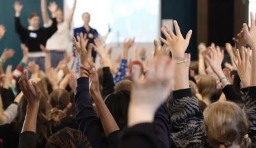 Hands go up in a classroom using Drama for Schools, a UT program