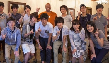 ELC students from Hitosubashi University smile and throw a "Hook 'em"" sign.